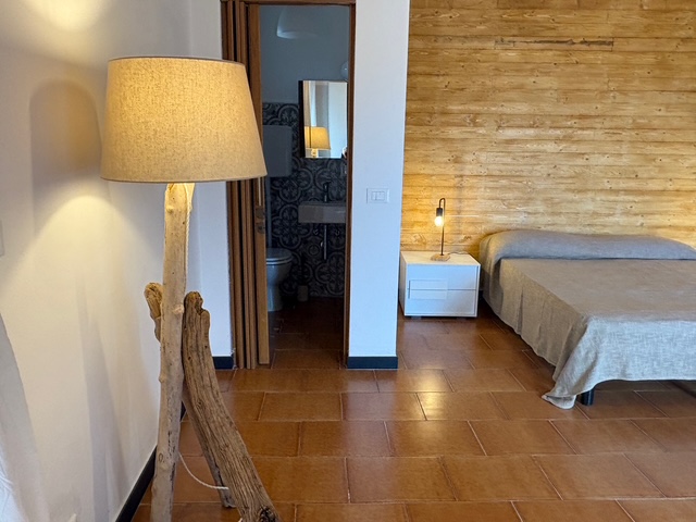 Camera con parete in legno e bagno - Ca Piera casa vacanze